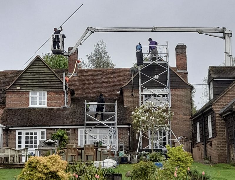 The Roof Moss Cleaners using cherry picker and scaffolding to clean roof safely and professionally in Raunds, Northamptonshire